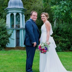 Micklefield Hall Wedding Photography - the newlyweds pose beside the historic folly