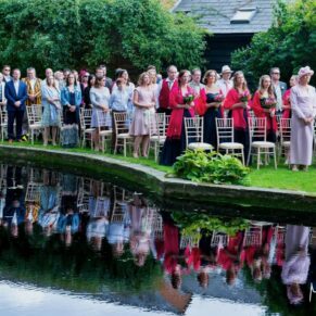Micklefield Hall Wedding Photography - the guests captured across the lake during the outdoor ceremony