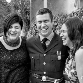 The groom enjoys some lively fun and banter with his sisters in the abbey grounds