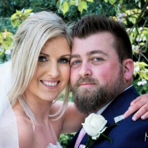 The loved up newlyweds pose for a closer-up portrait in the fabulous gardens of the abbey