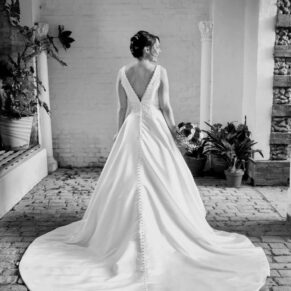 The back of the bride's dress captured in the summerhouse with atmospheric lighting at her summer marriage