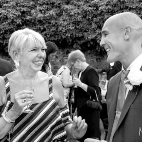 Monkton Barn Wedding Photography - the groom chatting to one of his guests