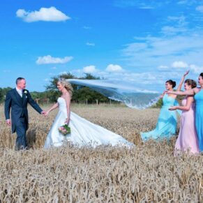 Notley Tythe Barn Wedding Photography - the newlyweds are joined by their bridesmaids for some relaxed photographs in the wheat fields nearby