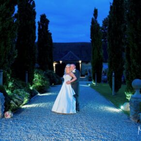 Notley Tythe Barn Wedding Photography - a dusk shot of the newlyweds on the driveway up to the barn