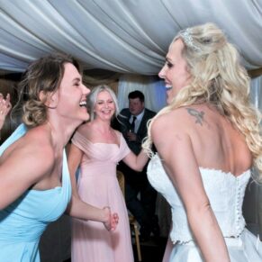 Notley Tythe Barn Wedding Photography - the bride enjoying a lively dance with her bridesmaids