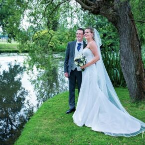 Odney Club Wedding Photography - the bride and groom stood by the waters edge