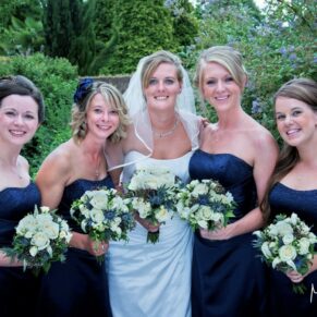 Odney Club Wedding Photography - the bride with her bridesmaids in the gardens