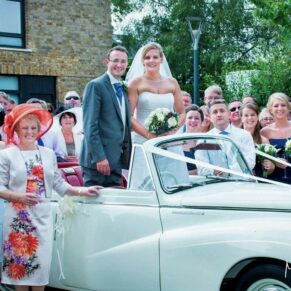 Odney Club Wedding Photography - the bride and groom stood up inside their morris minor