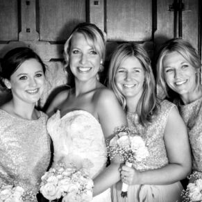 The bride with her bridesmaids captured with moody lighting inside the main entrance doorway to The Dairy
