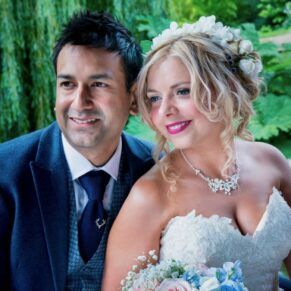 The newlyweds pose for the camera within one of the pavilions surrounded by romantic willow trees at The Dairy