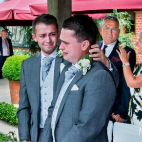 Emotions got the better of the groom as his best man comforts him when his bride to be makes her grand entrance for their marriage at The Dairy on the Waddesdon Estate