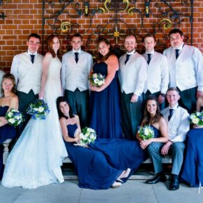 Relaxed bridal party group pose on the bench under the pavilion at The Dairy on the Waddesdon Estate