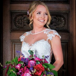The bride photographed against the main wooden entrance doorway at Waddesdon Manor with some gorgeous soft lighting