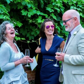 Candid moment of three giggling guests enjoying a catch up during the drinks reception at The Dairy