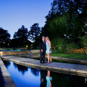 The newlyweds beside the floodlit water gardens at dusk at The Grove Hotel in Watford