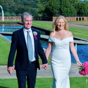 The newlyweds walking in the striking water gardens of The Grove Hotel on their wedding day