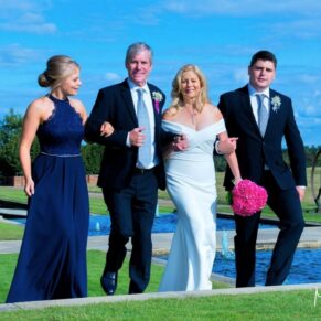 The bride and groom take a stroll with their son and daughter through The Grove Hotel's stunning grounds