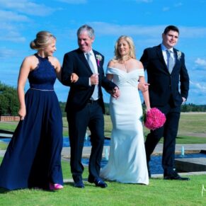The bride and groom take a stroll with their son and daughter through The Grove Hotel's stunning grounds