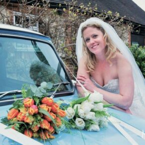 Old Luxters Wedding Photography - the bride leaning on the bonnet of her vintage mini