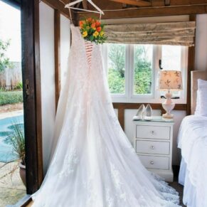 Old Luxters Wedding Photography - the bride's gown hanging up pre ceremony
