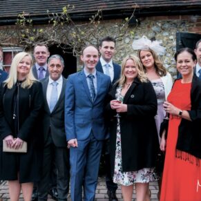 Old Luxters Wedding Photography - a group of guests gather for a relaxed group pose in the courtyard