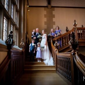 The bride and groom captured with stunning dramatic window lighting on the main staircase at their Pendley Manor Hotel wedding