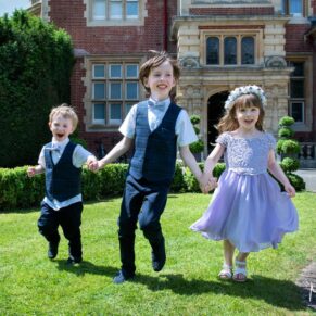Wedding kids running around the grounds of the Pendley Manor Hotel with happy smiles