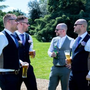 The boys enjoying the banter during the outdoor wedding drinks reception in the wonderful Pendley Manor Hotel gardens