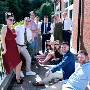 Wedding guests relaxing on the terrace during the drinks reception at Pendley Manor Hotel