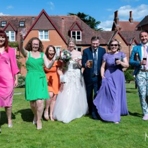 The newlyweds take a stroll in the gardens with their friends at their Pendley Manor Hotel wedding