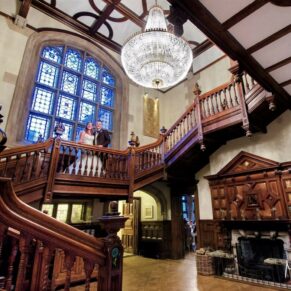 The newlyweds captured in a grand wide angle view of the staircase at their Pendley Manor Hotel wedding