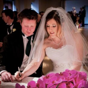 Stoke Place wedding photography - the newlyweds sign the register during the civil ceremony
