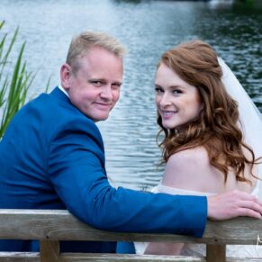 The newlyweds sat on a bench beside the River Thames at their Swan at Streatley wedding