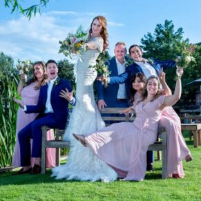 The wedding bridal party strike a fun photography pose next to the rive rat their Swan at Streatley Hotel venue