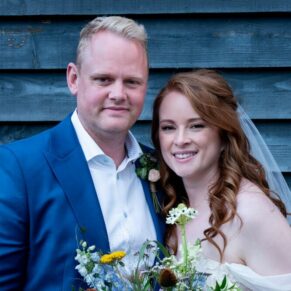 The Swan at Streatley Hotel - the newlyweds pose for the camera against a wooden backdrop