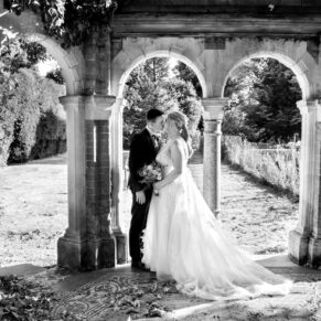 Dramatic black and white pose of the newlyweds in the ruined folly