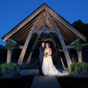 Dramatic floodlit night shot of the newlyweds in the grounds of the Tudor Barn in Burnham