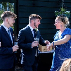 Reportage moment during the drinks reception of some guests enjoying the banter at the Tudor Barn