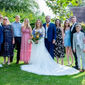 Small wedding family group pose in the summery gardens at The Olde Bell in Hurley