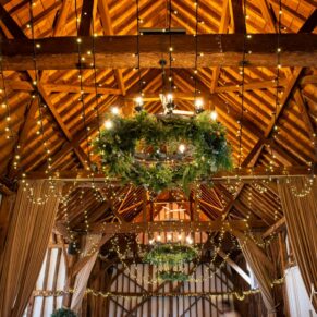 Looking up high into the rafters to see the wonderful wedding decorations in the historic barn at The Olde Bell in Hurley