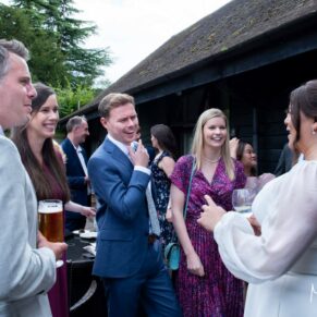 Reportage image of the wedding guests enjoying the wedding party vibe during the courtyard drinks reception at The Olde Bell in Hurley
