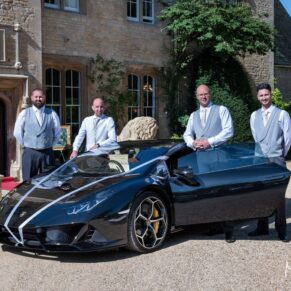 The lads pose with the sports car on the hotel driveway near the main entrance