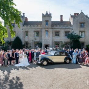 Big group pose of everyone beside the vintage car in front of the main entrance at Weston Manor Hotel