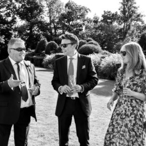 Reportage picture captured during the drinks reception of three friends giggling in the gardens of Weston Manor Hotel