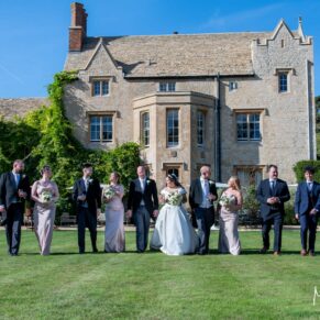 The bridal party take a stroll under perfect blue skies with the historic Weston Manor in the background