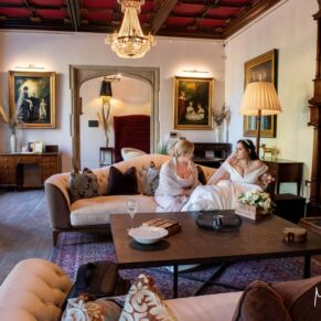 The bride relaxes with her bridesmaid in the reception area surrounded by the stunning interiors of this historic venue