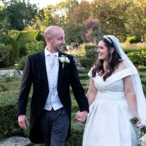 The bride and groom walking through the fabulous gardens on their wedding day at Weston Manor