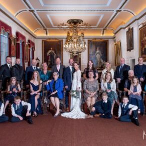 The newlyweds pose for the camera inside the Guildhall with all of their guests prior to their wedding reception at the Castle Hotel