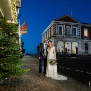 Photography of the newlyweds captured in front of the Christmassy Castle Hotel and Guildhall at nightfall at dusk on their wedding day in Windsor