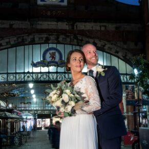 Photography of the newlyweds captured in front of Windsor Train Station after dusk at their Castle Hotel wedding